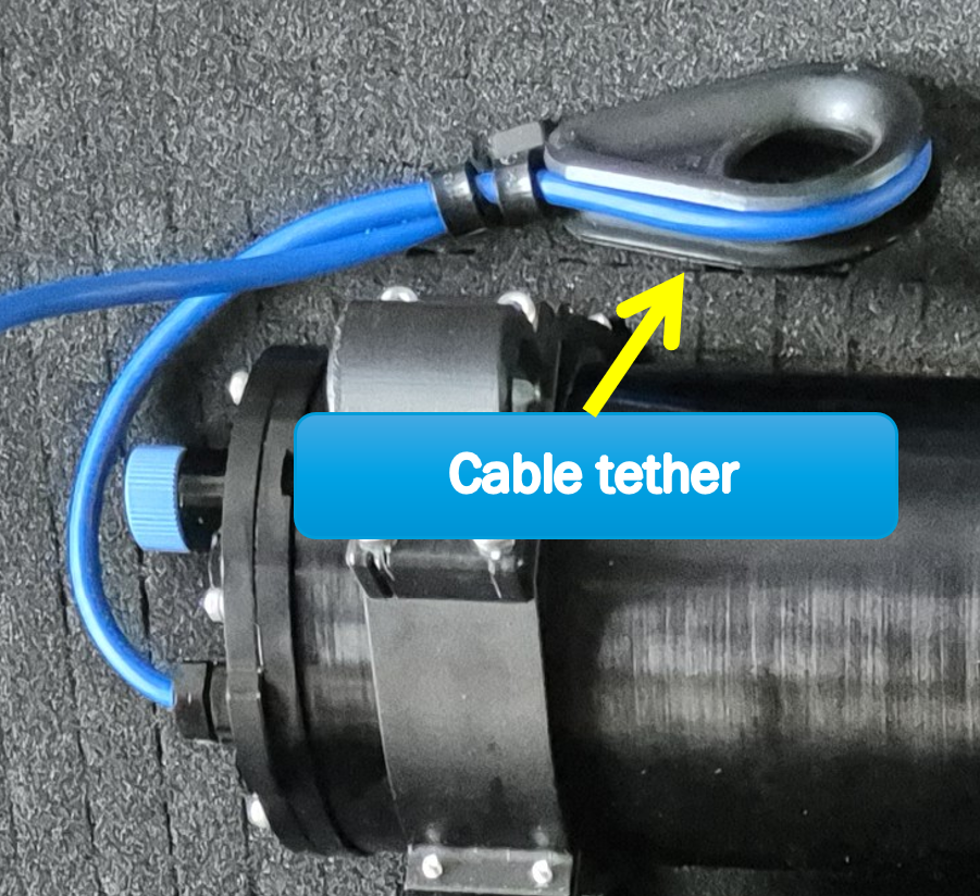 The cable tether wrapped around the device's cable and secured with tie-wraps